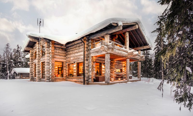 Snowy log cabin pictured from outside