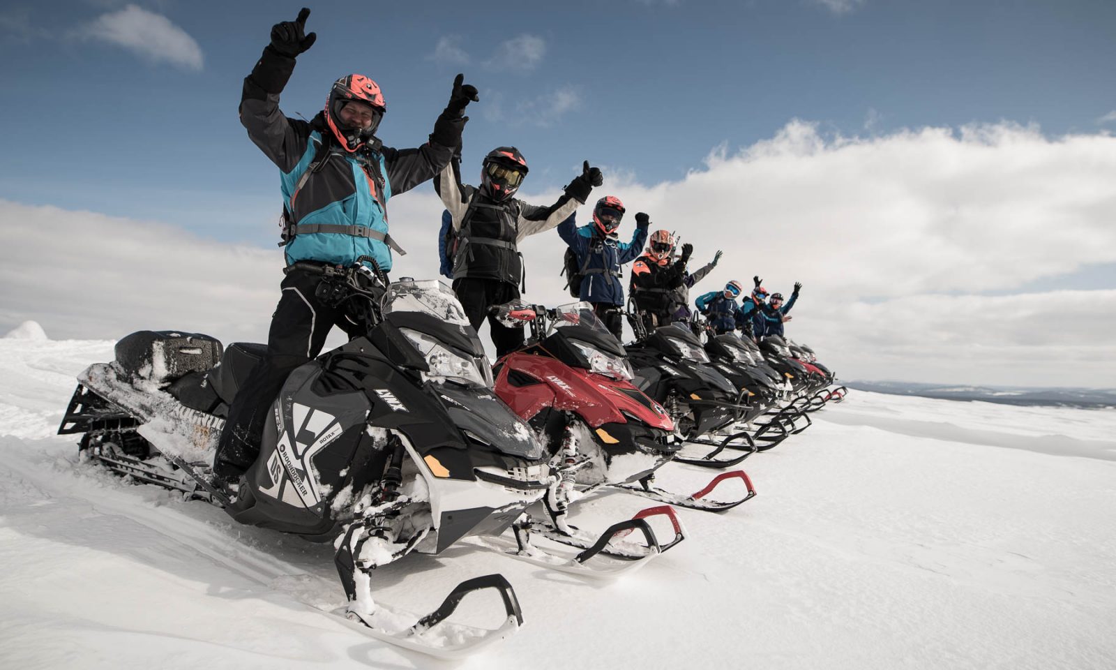 Many people cheering while standing on snowmobiles. Rovaniemi / Arctic Expeditions – Russian Border Adventure, Wild Nordic Finland @wildnordicfinland