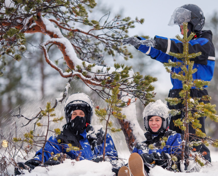 Tourists playing in the snow during a snowmobile safari with Wild Nordic Finland in Rovaniemi, Lapland